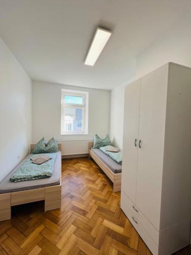 a large room with two beds and a window at Big Travel Group Leoben in Leitendorf