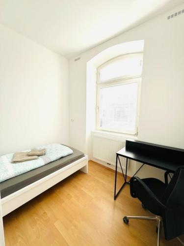 a bedroom with a bed and a desk and a window at Central - Modern - Free Parking - Top2 in Leitendorf
