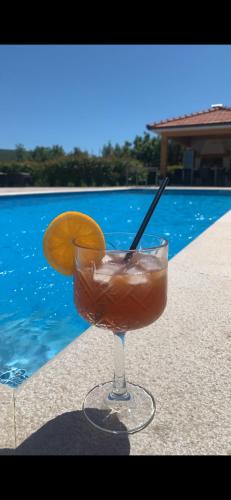 a drink in a glass next to a swimming pool at Luxury Villa ROYAL in Ljubuški