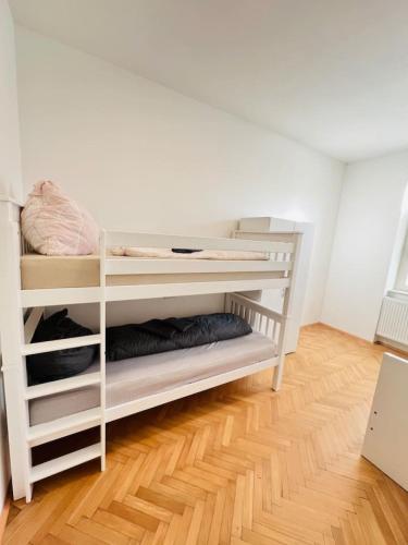 a white bunk bed in a room with a wooden floor at Villa Rebuli - room - zentral leben in der Top3 in Leitendorf