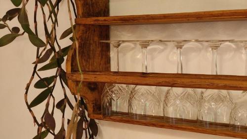 a wooden shelf with wine glasses on it at Abendsonne in Saulgrub