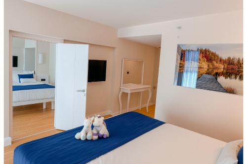 two stuffed animals sitting on a bed in a bedroom at Orbi City - Sea View Aparthotel in Batumi in Batumi