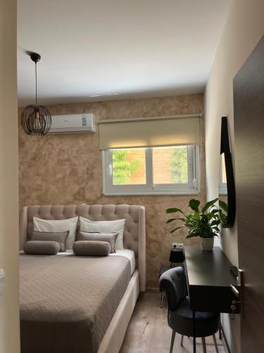 a bedroom with a bed and a desk and a window at Amare suite in Perivólia