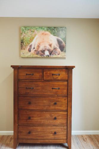 a painting of a bear laying on top of a dresser at Lakeshore Lodging Apartment F in Homer