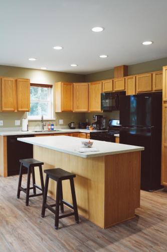 a kitchen with a large island with two stools at Lakeshore Lodging Apartment F in Homer