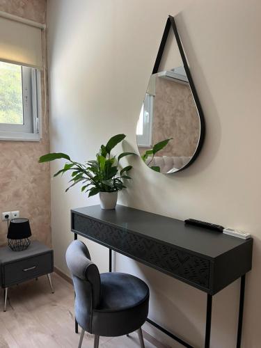 a black desk with a mirror and a chair at Amare suite in Perivólia