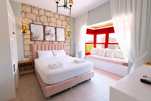 Un dormitorio con una cama grande y dos ventanas. en Karnelyan Alaçatı, en Cesme
