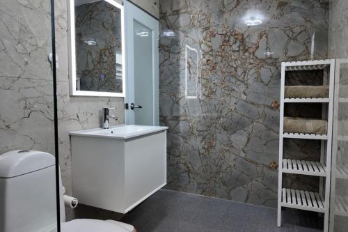 a bathroom with a white sink and a toilet at VSS La Puntilla in Arecibo - Stylish Coastal Getaway in Arecibo