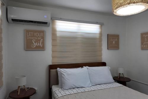 a bedroom with a bed and a window with a blind at VSS La Puntilla in Arecibo - Stylish Coastal Getaway in Arecibo