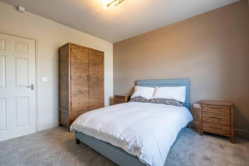 a bedroom with a blue bed and a wooden cabinet at Cartercroft, Sheffield in Sheffield