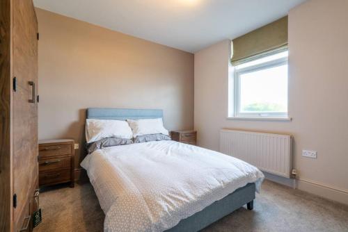a bedroom with a bed with a blue headboard and a window at Cartercroft, Sheffield in Sheffield