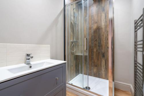 a bathroom with a glass shower and a sink at Cartercroft, Sheffield in Sheffield