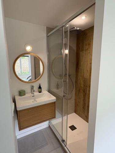 une salle de bain avec un lavabo et une douche dans l'établissement Maison en Pierre au calme, à Binic