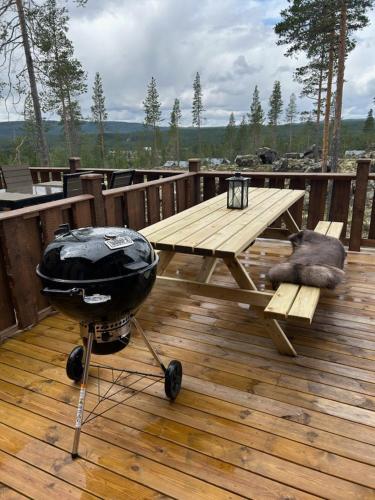 a grill and a picnic table on a deck at "Rockyhill" Affordable beautiful luxury Lodge Idre sauna in Idre