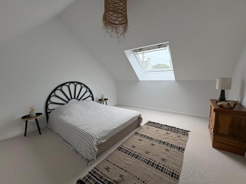 - une chambre avec un lit, une fenêtre et un tapis dans l'établissement Maison en Pierre au calme, à Binic