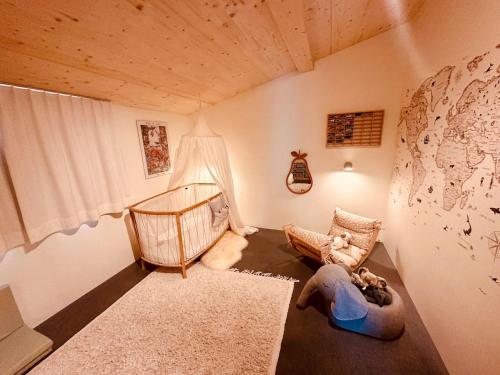 a childs room with a crib and a childs bed at Luxury family Chalet with extraordinary Mountain views in Trin