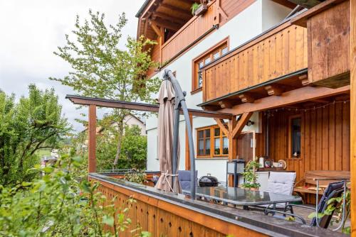 Un patio al aire libre con una mesa y una sombrilla en una casa. en Ferienwohnung am Fuchsbühl, en Schopfheim