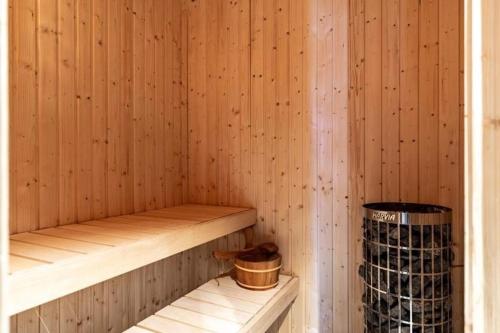a wooden sauna with a wooden shelf and a bucket at "Rockyhill" Affordable beautiful luxury Lodge Idre sauna in Idre