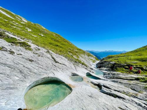 a rock quarry with a pool of water in a river at Luxury family Chalet with extraordinary Mountain views in Trin
