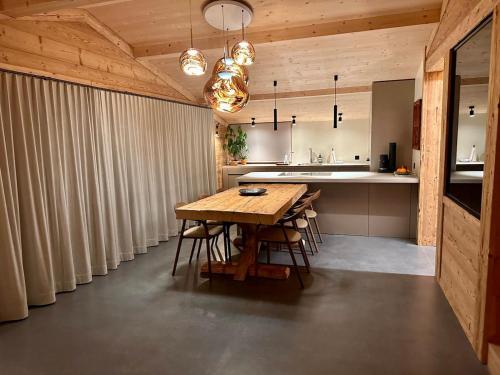 a large kitchen with a wooden table and chairs at Luxury family Chalet with extraordinary Mountain views in Trin