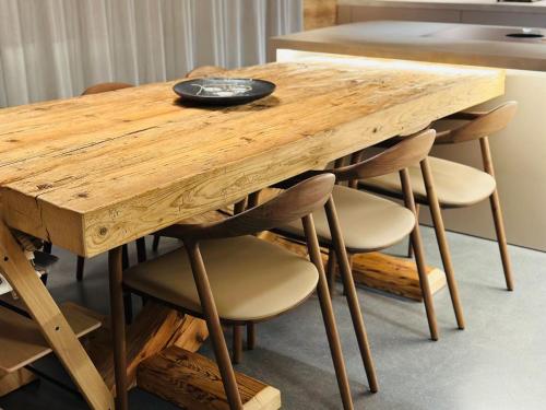 a wooden table and chairs with a wooden table and a plate on it at Luxury family Chalet with extraordinary Mountain views in Trin