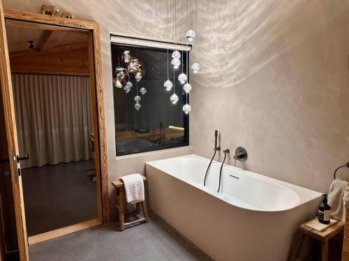 a large bath tub in a bathroom with a mirror at Luxury family Chalet with extraordinary Mountain views in Trin