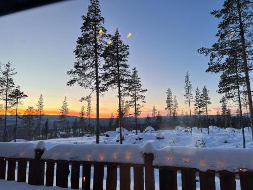 a snow covered yard with trees and a sunset at "Rockyhill" Affordable beautiful luxury Lodge Idre sauna in Idre