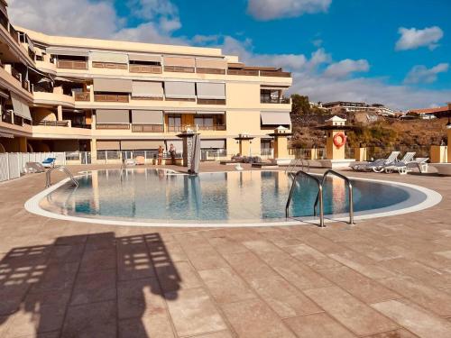 a large swimming pool in front of a building at Puesta del sol en playa arena in Puerto de Santiago