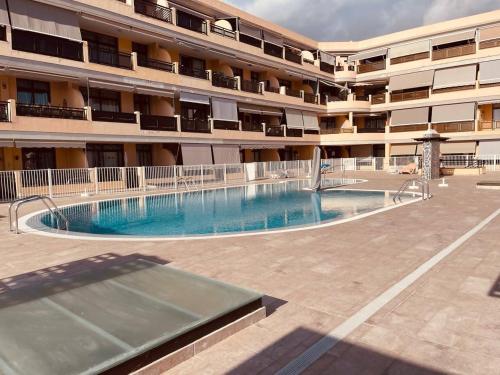 a swimming pool in front of a building at Puesta del sol en playa arena in Puerto de Santiago