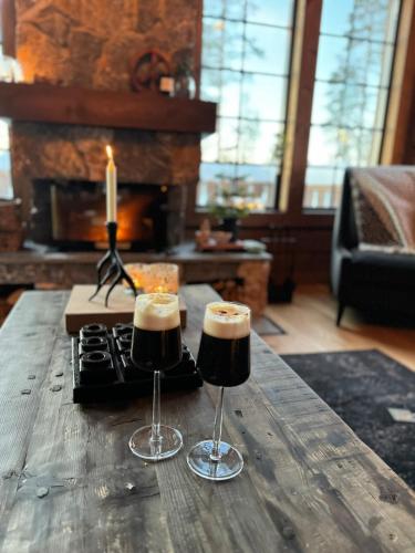 two wine glasses on a wooden table with a candle at "Rockyhill" Affordable beautiful luxury Lodge Idre sauna in Idre