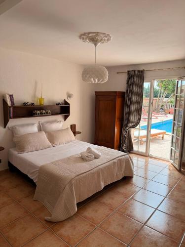 une chambre avec un grand lit et une piscine dans l'établissement La Villa Catalane, à Bompas