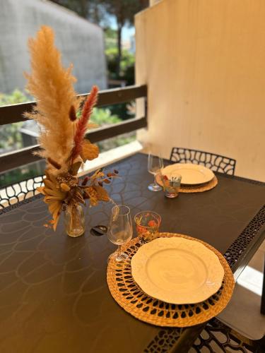 une table noire avec des assiettes et des verres dans l'établissement 5 personnes piscine pinède et mer, au Cap d'Agde