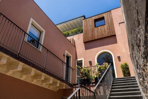 an apartment building with stairs and balconies at Creuza De Ma in Riposto