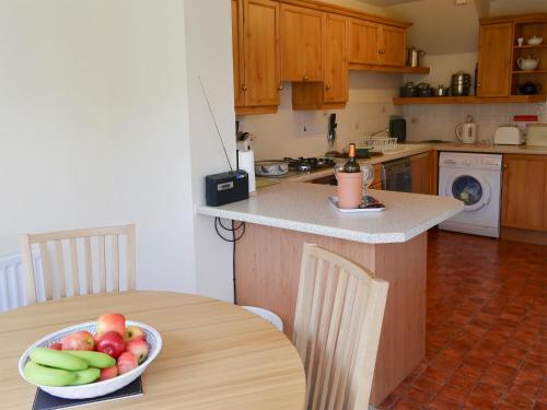 a kitchen with a table with a bowl of fruit on it at Millside in Morpeth