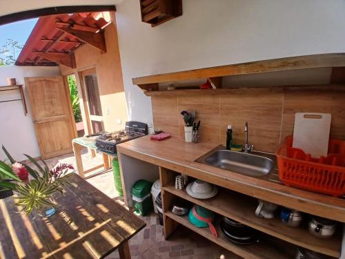 a kitchen with a sink and a counter with a table at Sexto Sentido Cabañas & Pan Frances in Palomino