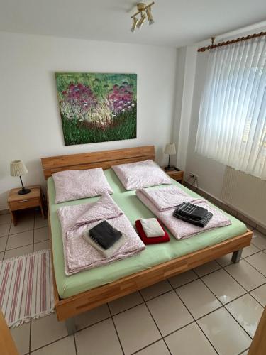 a bedroom with a bed with a painting on the wall at Ferienwohnung Schlichting in Travemünde