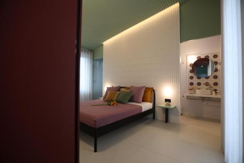 a bedroom with a bed with pink sheets and pillows at Palazzo Novecento in Cassano delle Murge