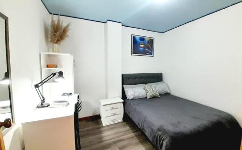 una camera da letto con un letto e una scrivania con una lampada di Suite Boreal a Riobamba
