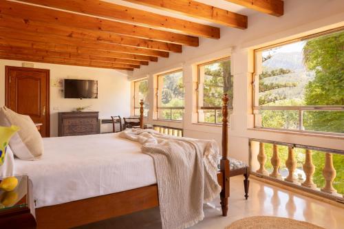 a bedroom with a bed in a room with windows at Agroturismo Son Galceran in Esporles