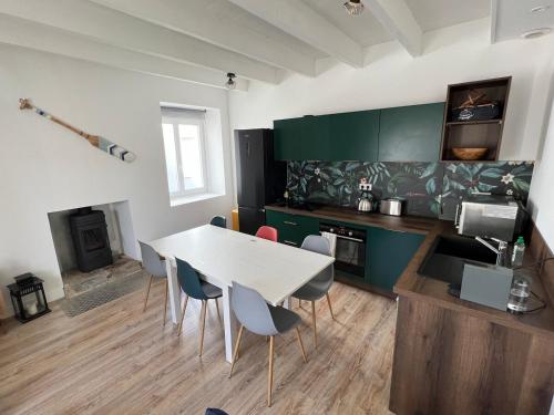 une cuisine avec une table et des chaises dans une pièce dans l'établissement Charmant Penty proche toutes commodites, au Guilvinec