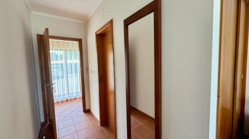 a hallway with two doors and a tile floor at Raízes da Vinha - Quartos & Chalé na Serra da Estrela in Carragozela