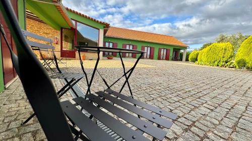 two benches sitting in front of a building at Raízes da Vinha - Quartos & Chalé na Serra da Estrela in Carragozela