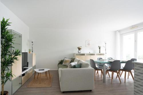 een woonkamer met een bank en een tafel bij Horizon Paisible - Piscine et parking ! in Toulouse