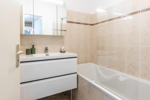 een badkamer met een witte wastafel en een bad en een badkuip bij Horizon Paisible - Piscine et parking ! in Toulouse