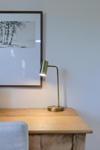 a desk with a lamp on top of a wooden table at Homestead Haven in Gettysburg