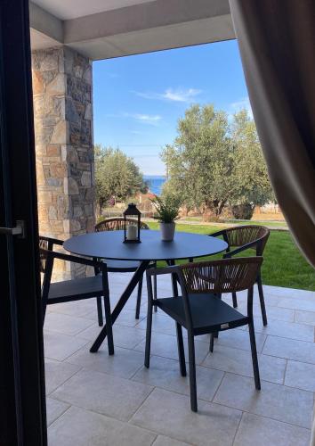 a table and chairs on a patio with a view at Aelia Stone Houses in Soúrpi