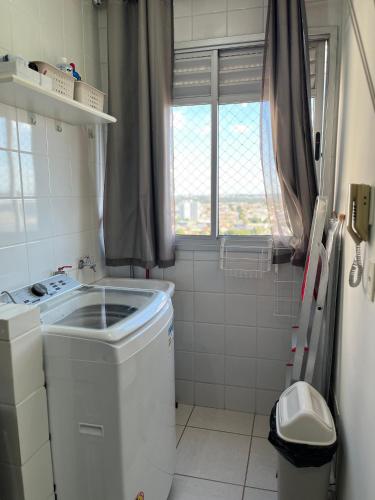 a small bathroom with a washing machine and a window at Melhor Experiência em Cuiabá in Cuiabá