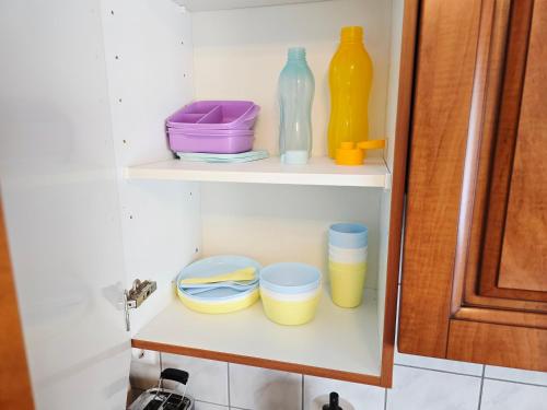 a shelf with bowls and bottles on it in a kitchen at Ferienwohnung 1 - Nähe Phantasialand, Köln, Bonn, Brühl in Weilerswist