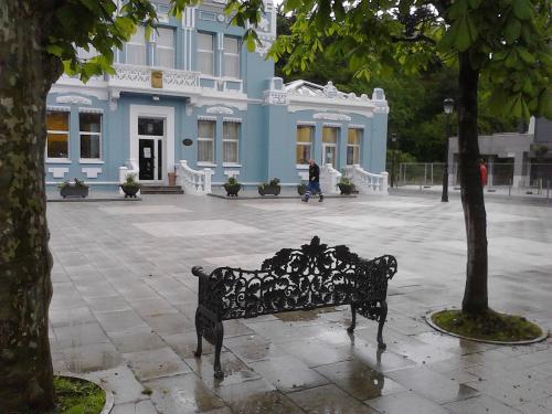 a black bench in front of a blue building at Posada Casa de Valle in Colindres