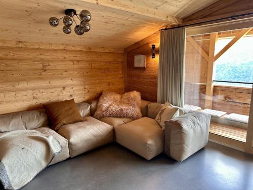 a leather couch in a room with a window at Luxury family chalet with extraordinary views in Trin
